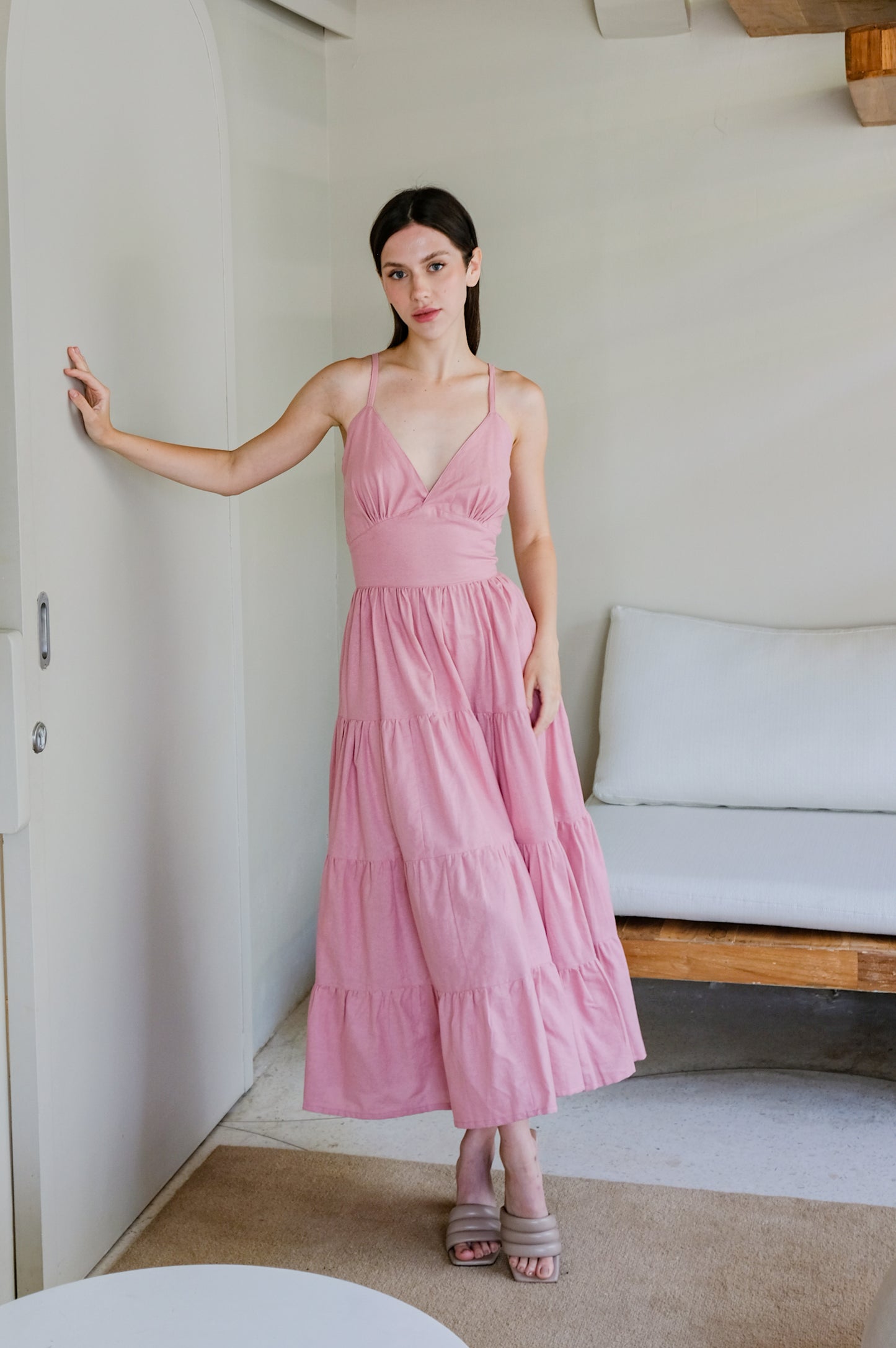 Wide linen dress in pink colour displayed by model.