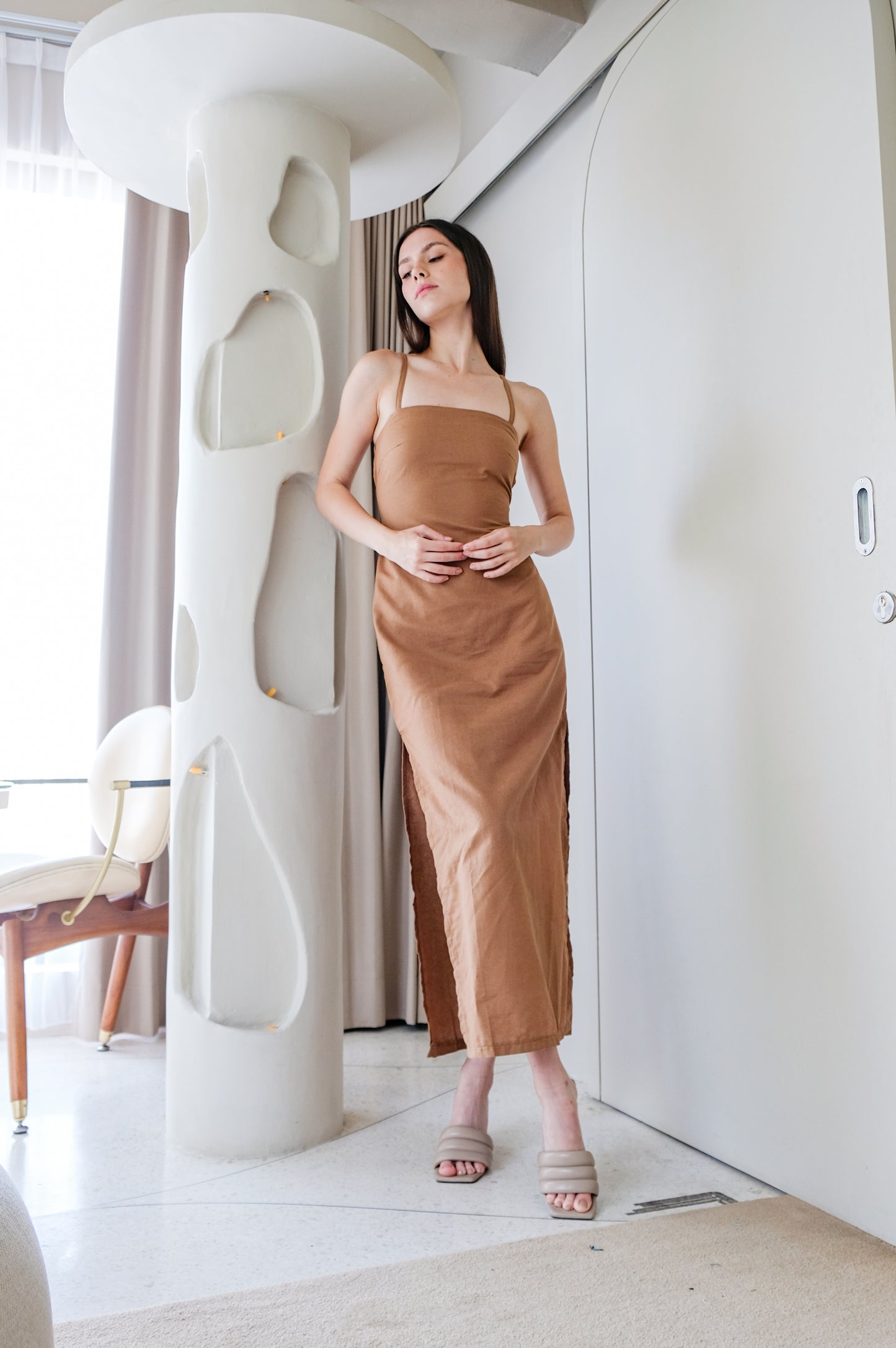 Vichy linen dress in brown colour by Una Linen Havn worn by model.