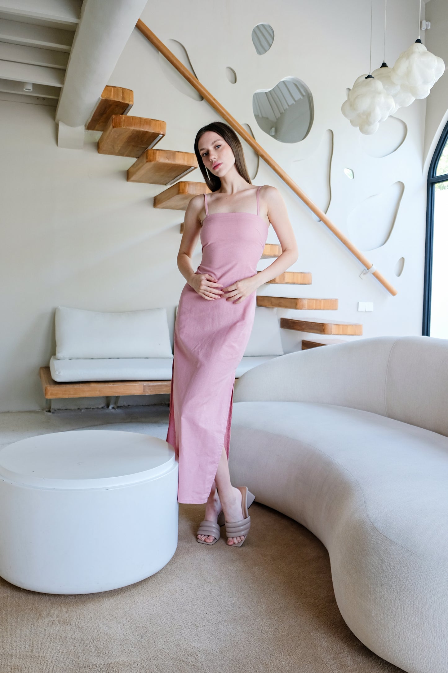 Minimalistic pink linen dress worn by model in luxurious interior.
