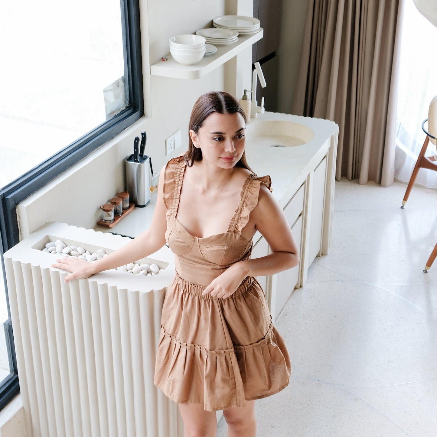 Brown set of linen clothes worn by model in light tone interior.