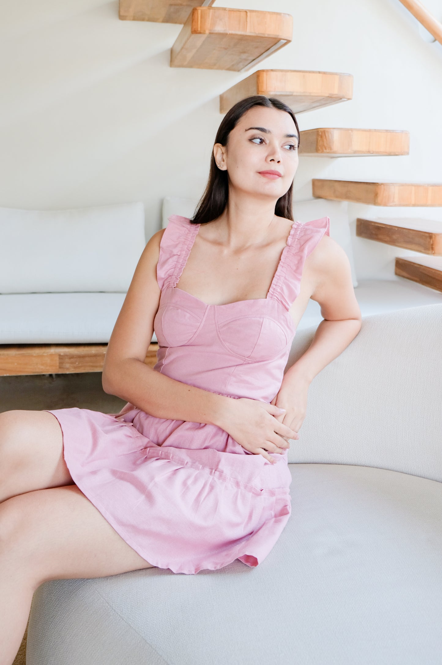 Pink set of top and skirt called CItadella wear by model while sitting.