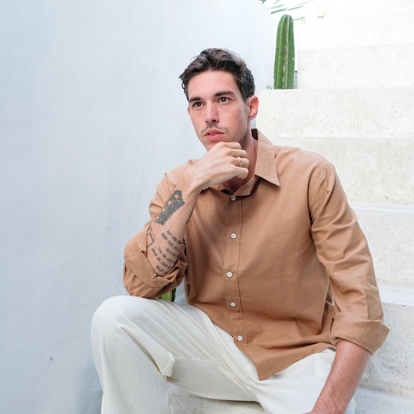 Model thinking about buying new linen shirt and trousers in brown and white colour by Una Linen Havn