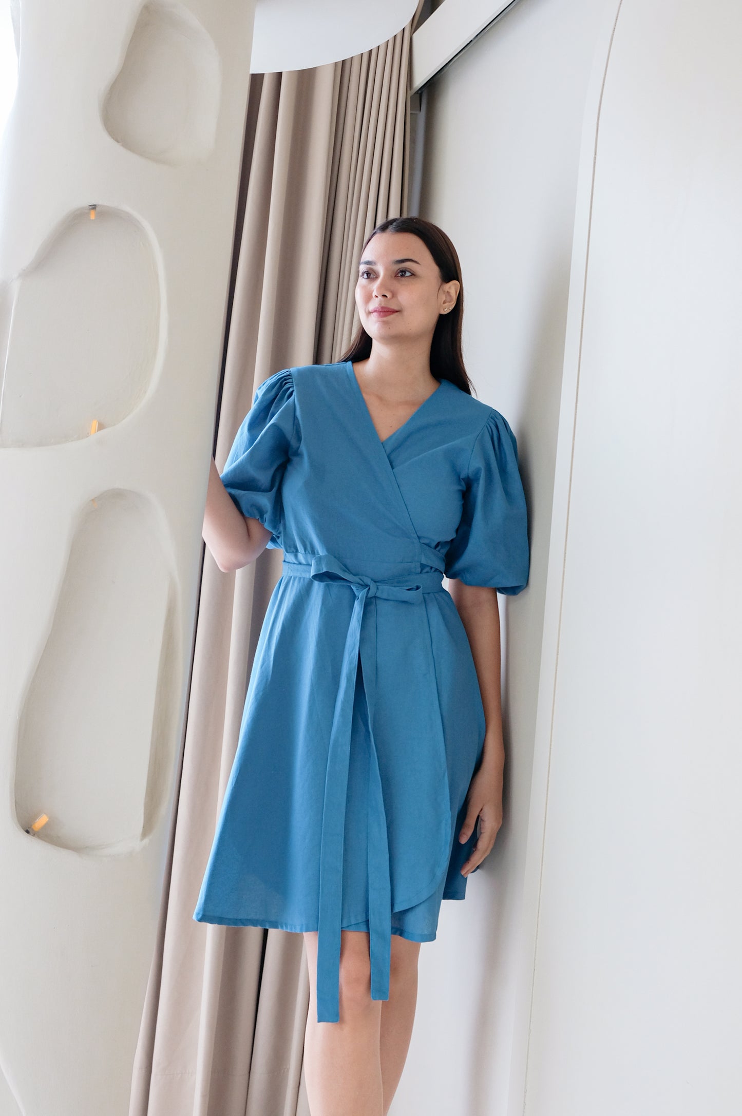Blue kimono dress Kvilda made of linen wear by model in minimalistic interior.