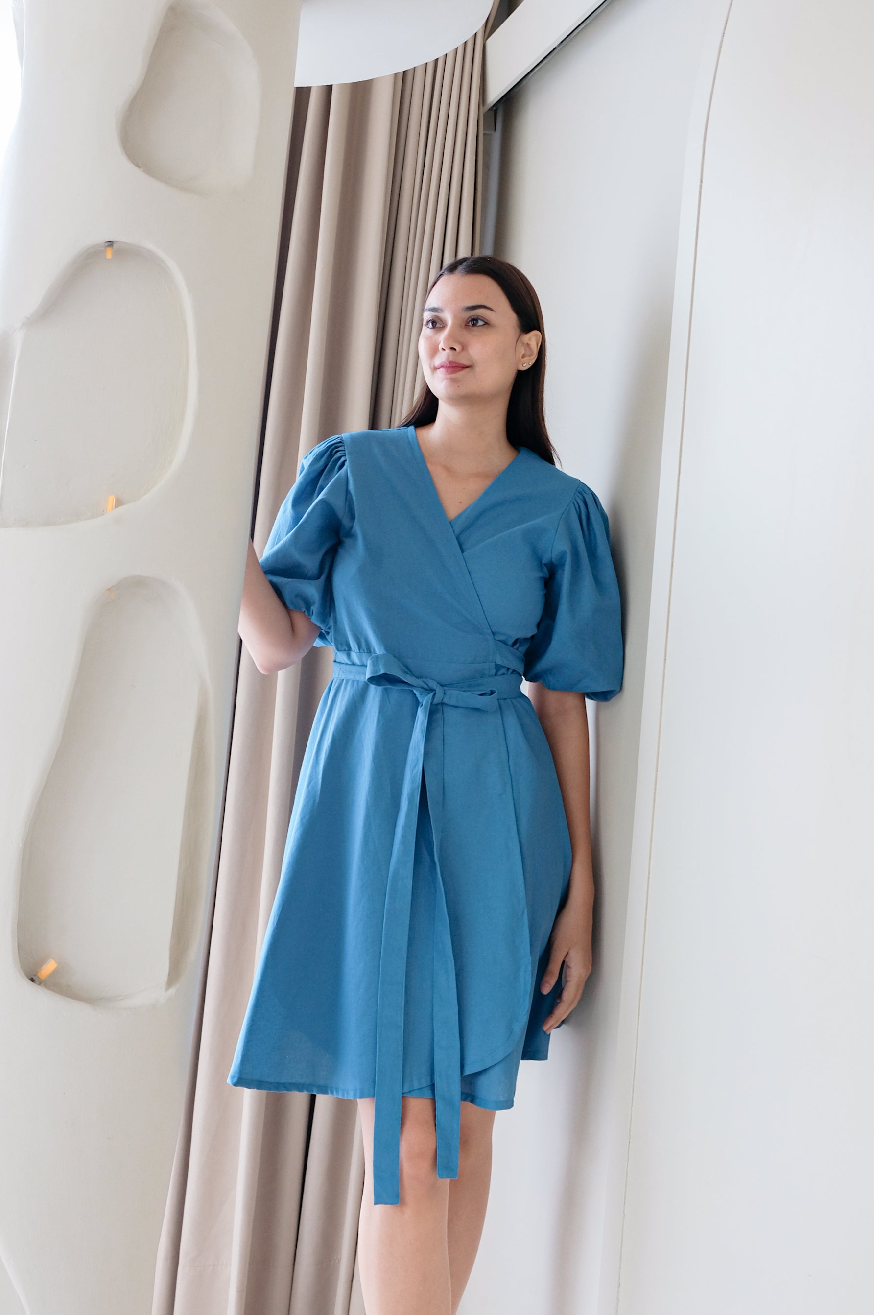 Blue kimono dress Kvilda made of linen wear by model in minimalistic interior.