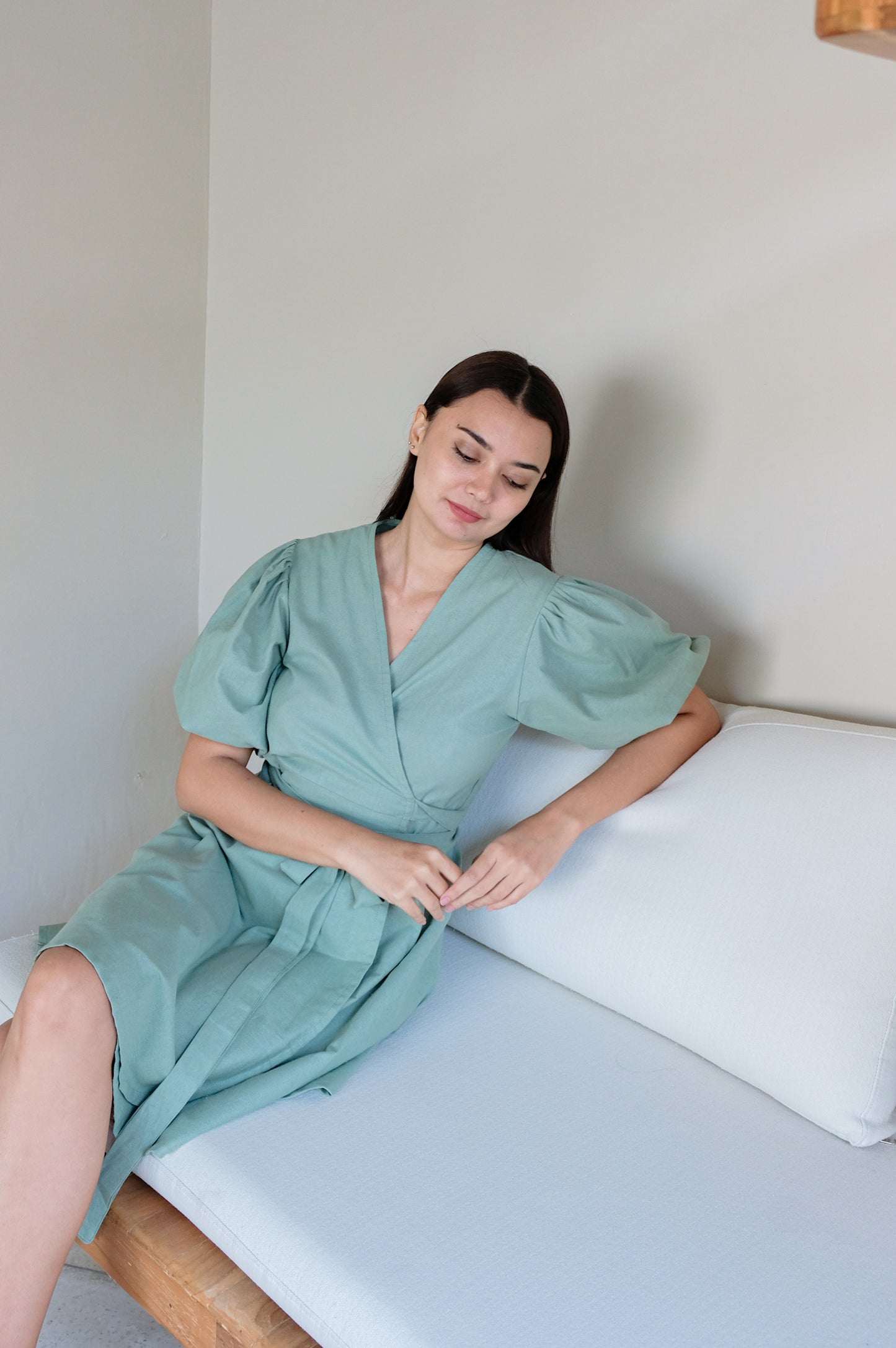 Green linen kimono dress on a sitting model.