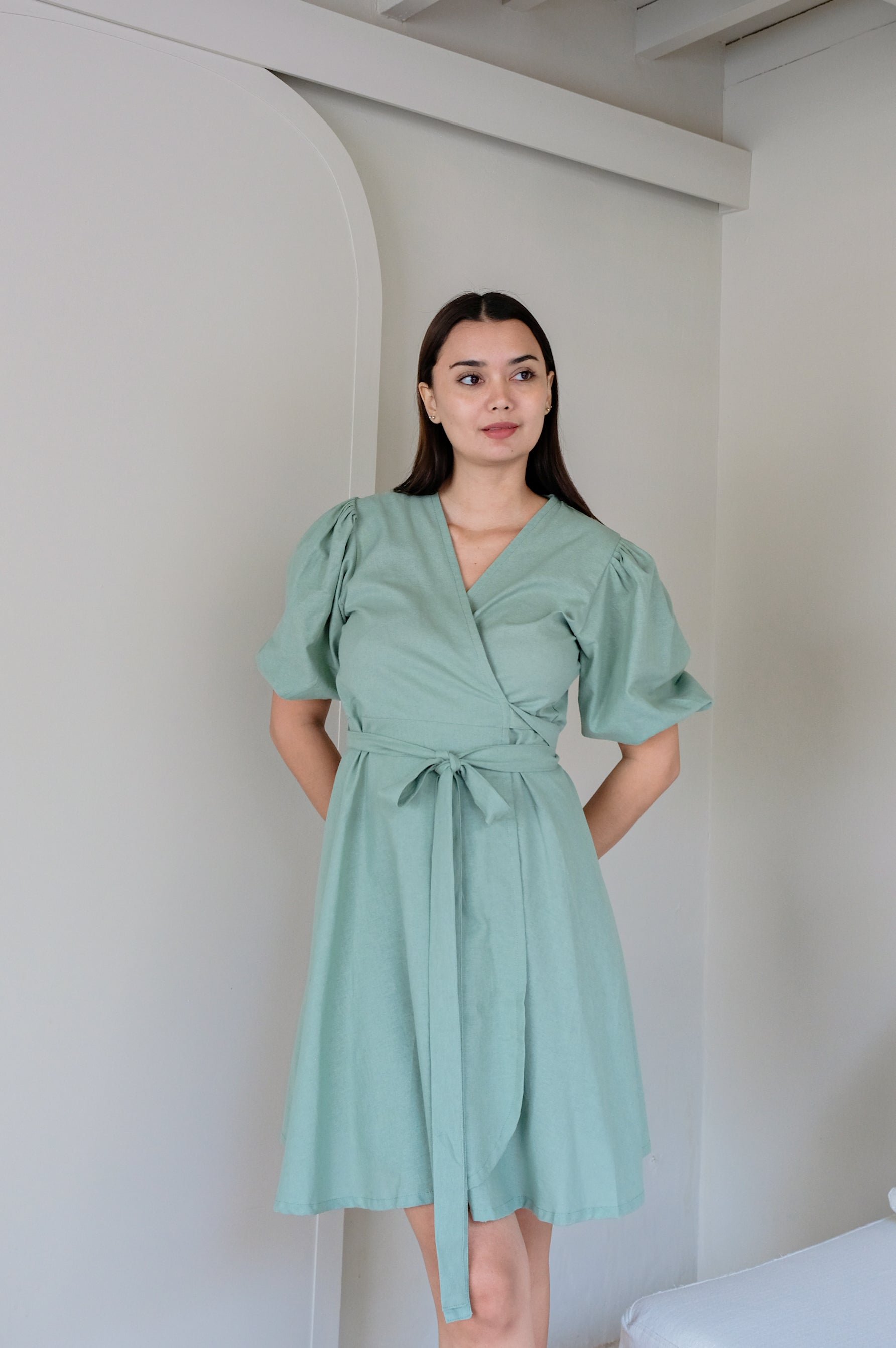 Woman trying her new green kimono design dress feeling comfortable.